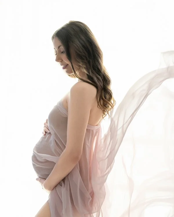 Melbourne pregnancy photographer image of a pregnant woman in the studio wearing  flowing fabric