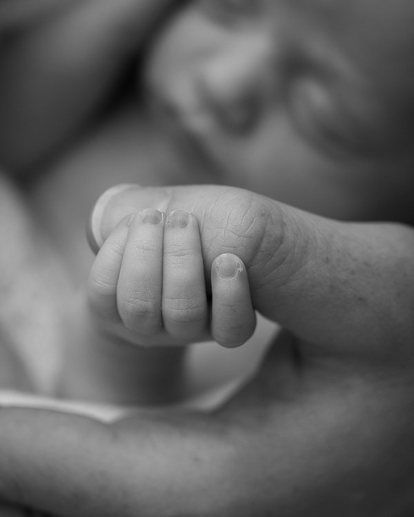 Best Melbourne newborn photographer monochrome macro image of a newborn baby hand holding onto her father's thumb