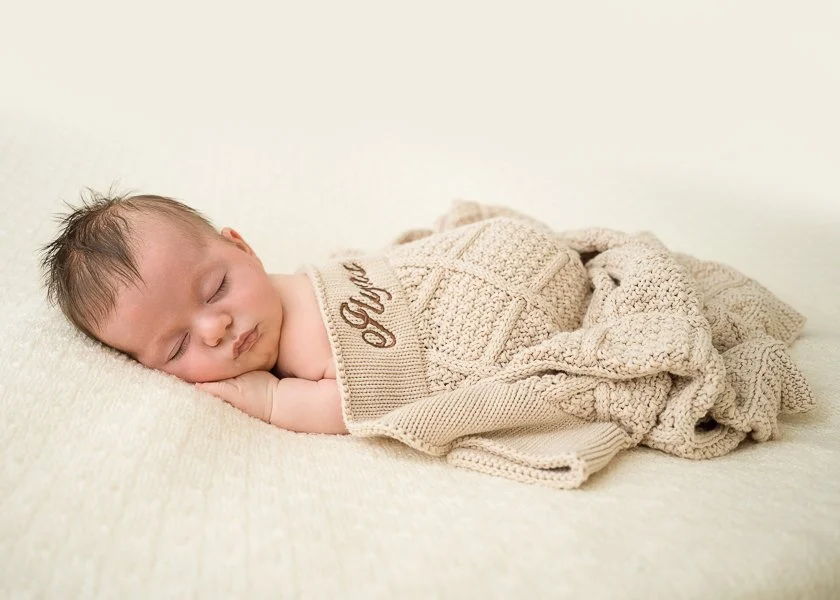Photo of an older sleeping baby covered in a blanket