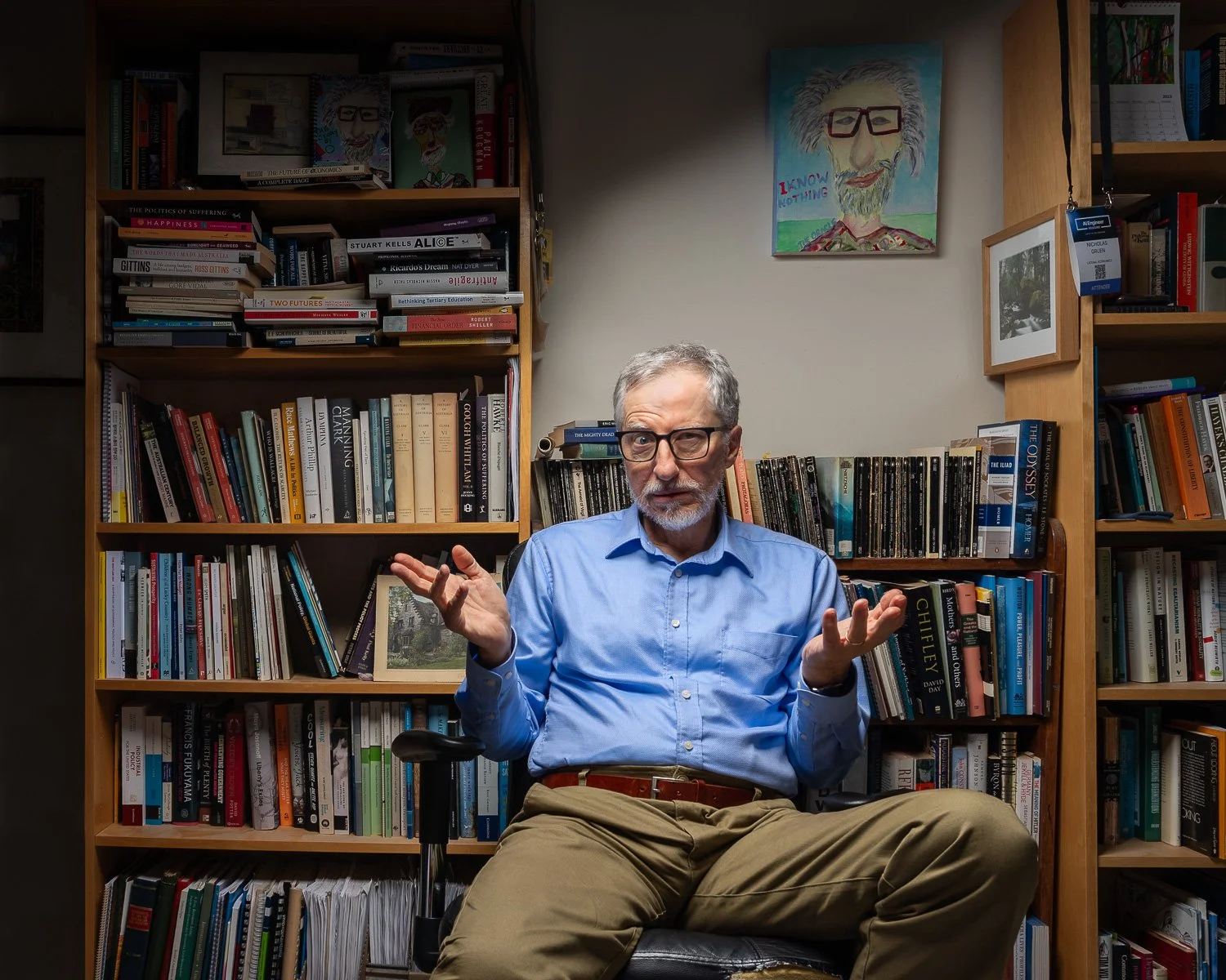 Portrait of economist Nicholas Gruen surrounded with books