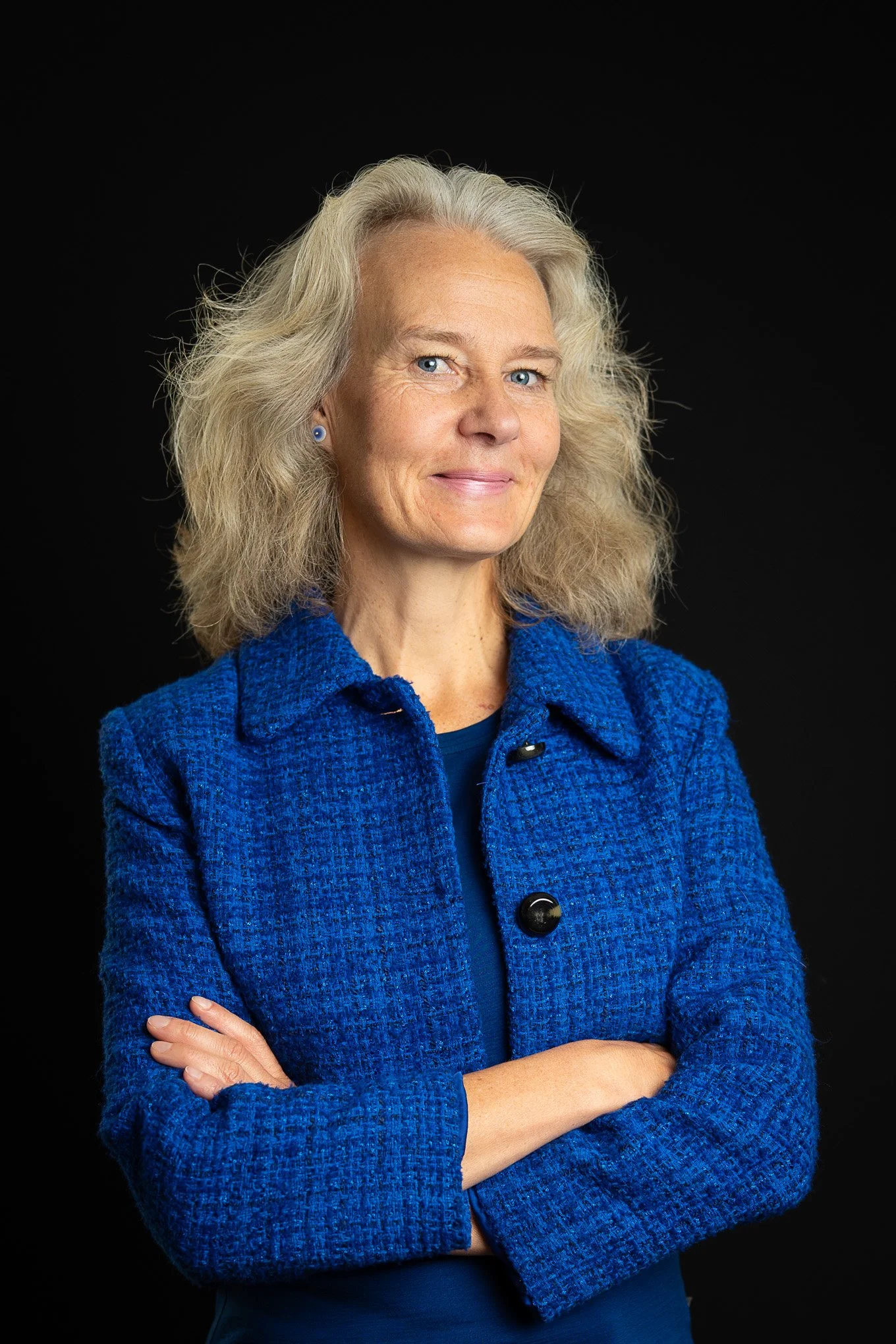 Portrait of Karin in a blue blazer with arms folded