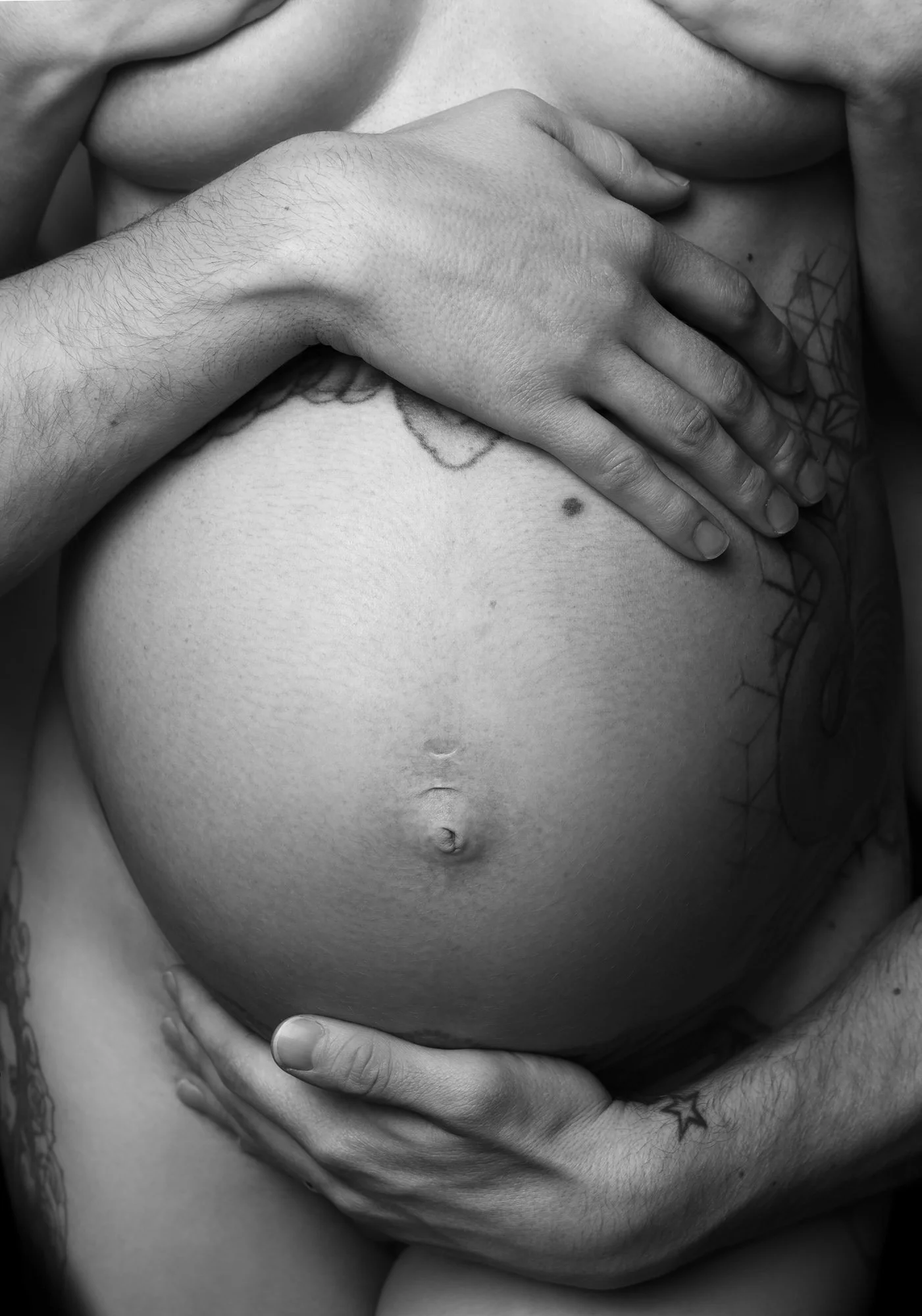Detailaufnahme eines Paares mit Fokus auf den Babybauch. Zeitlose Schwangerschaftsfotografie im Fine-Art-Stil in Düsseldorf