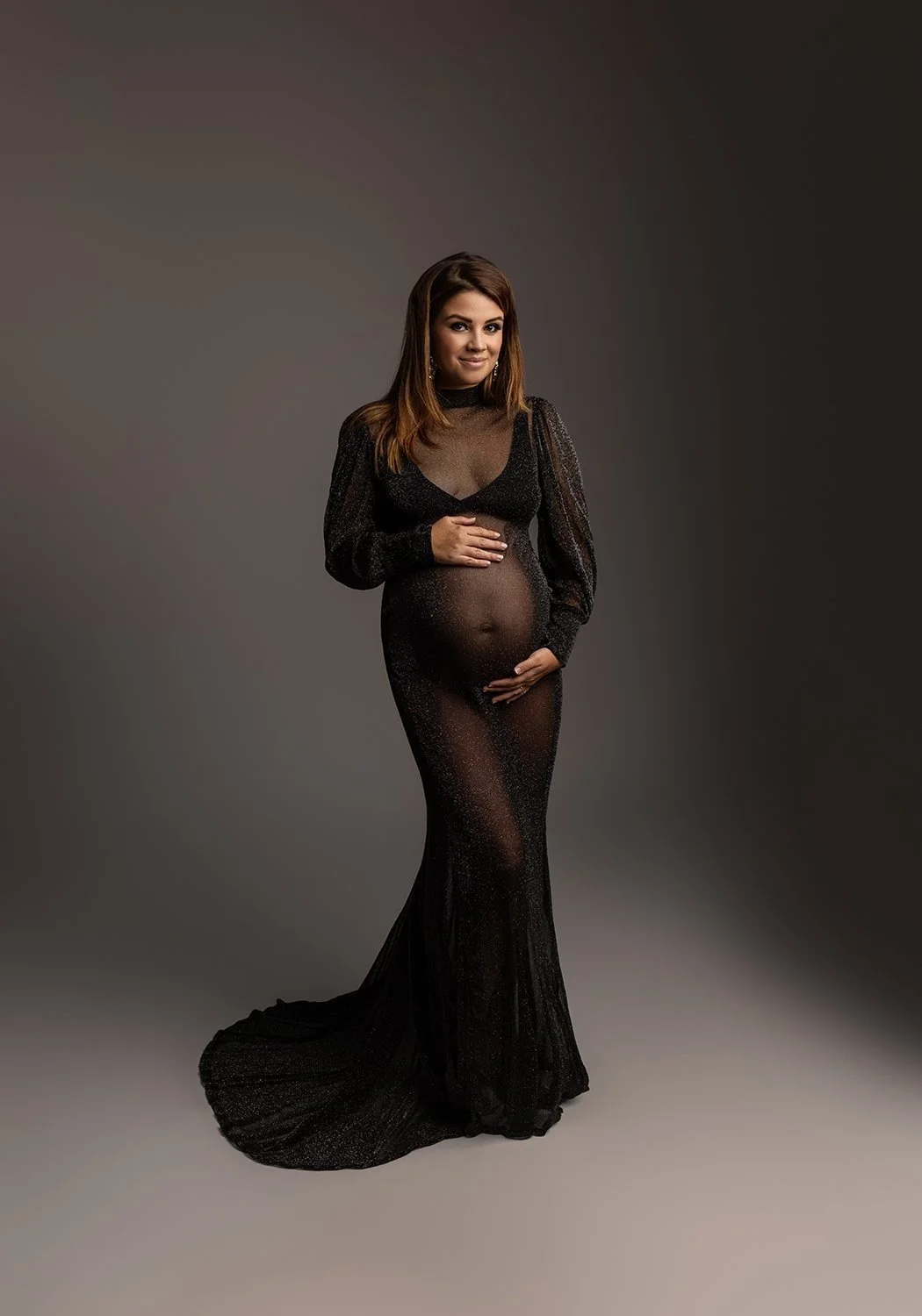 Werdende Mutter in einem fließenden, durchsichtigem Kleid während eines Babybauchfotoshootings. Modeorientierte und elegante Schwangerschaftsfotografie in Düsseldorf.