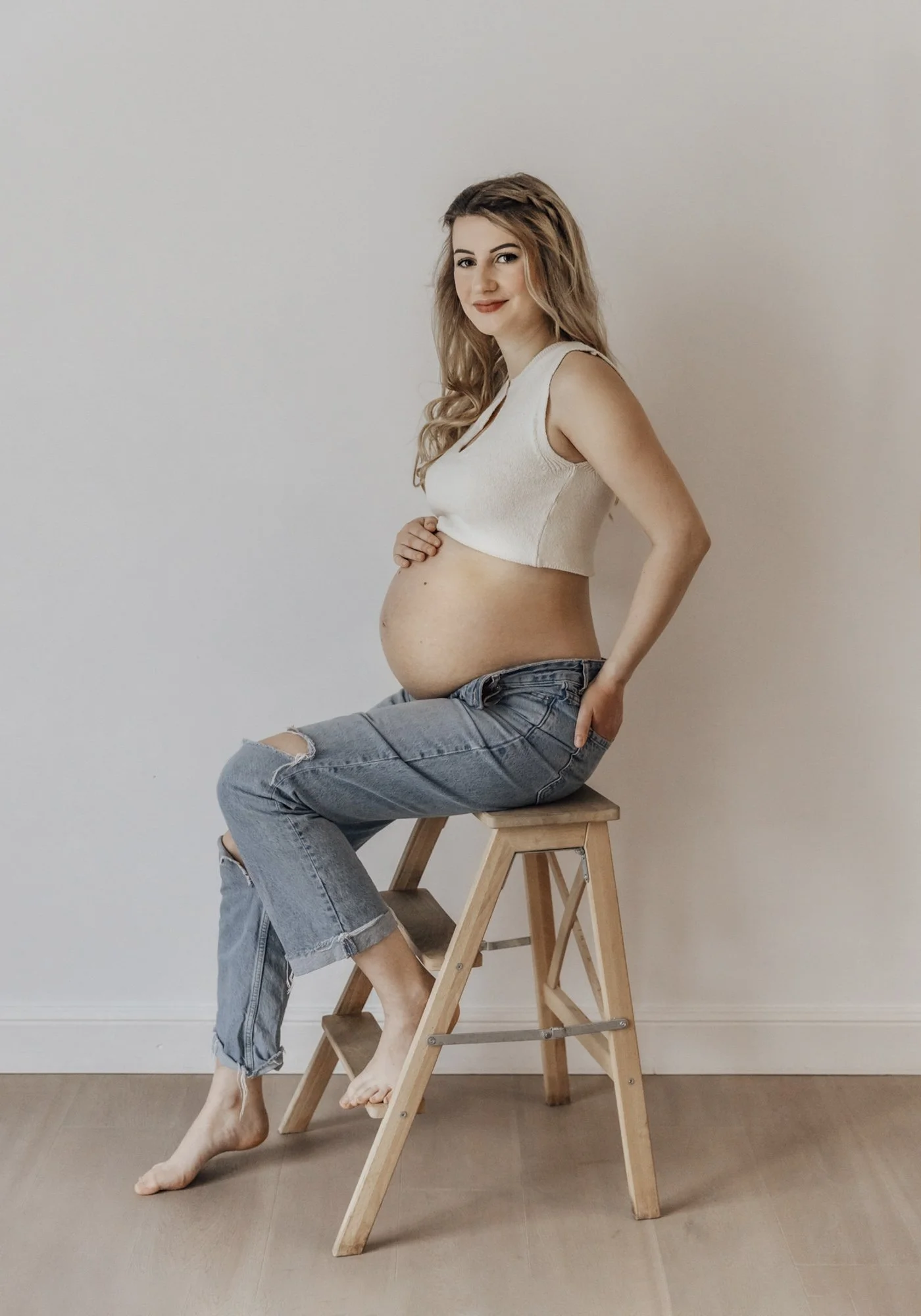 Schwangerschaftsfotoshooting einer werdenden Mama im natürlichen Stil und lässigem Outfit