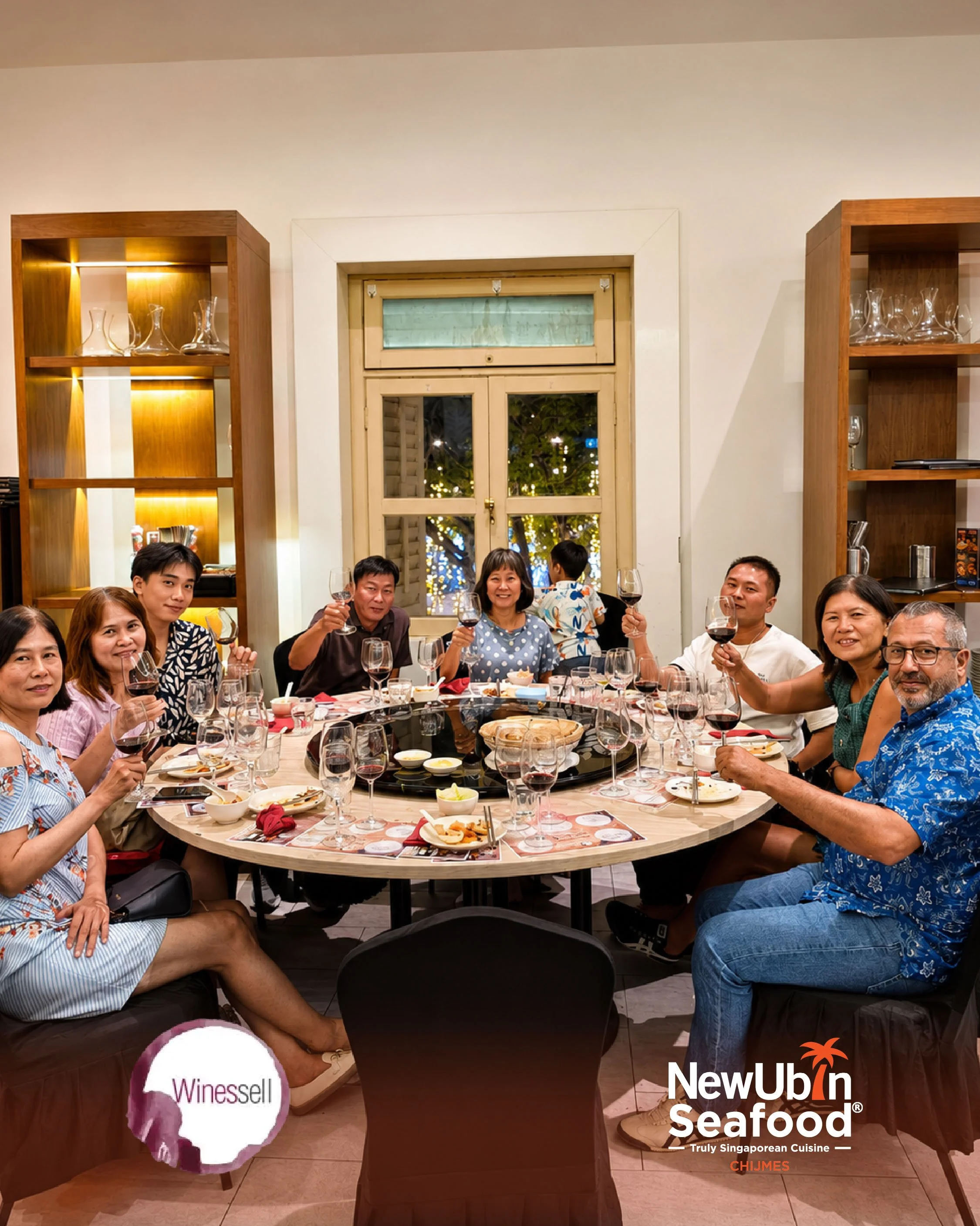 A group of people sitting around a dinner table enjoying a meal and drinks during the Truly Singaporean Makan and Minum wine pairing event.