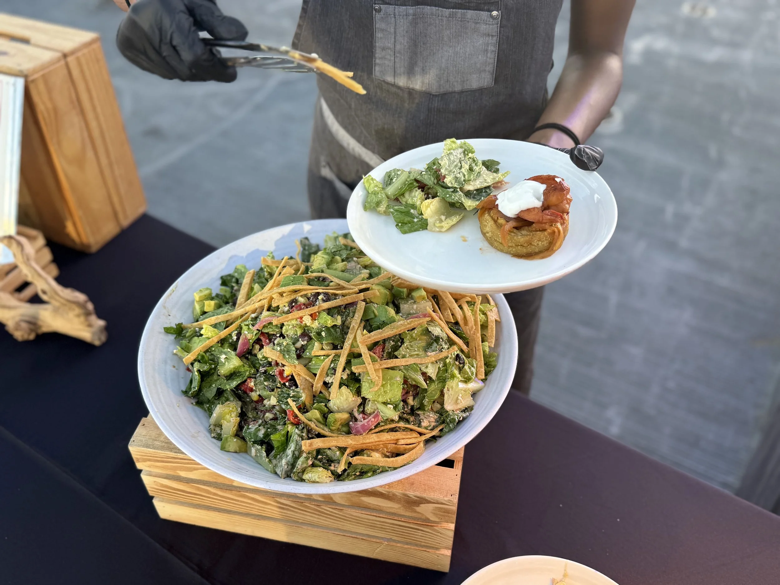 Plated salad by a chef with arepa for an outdoor event.