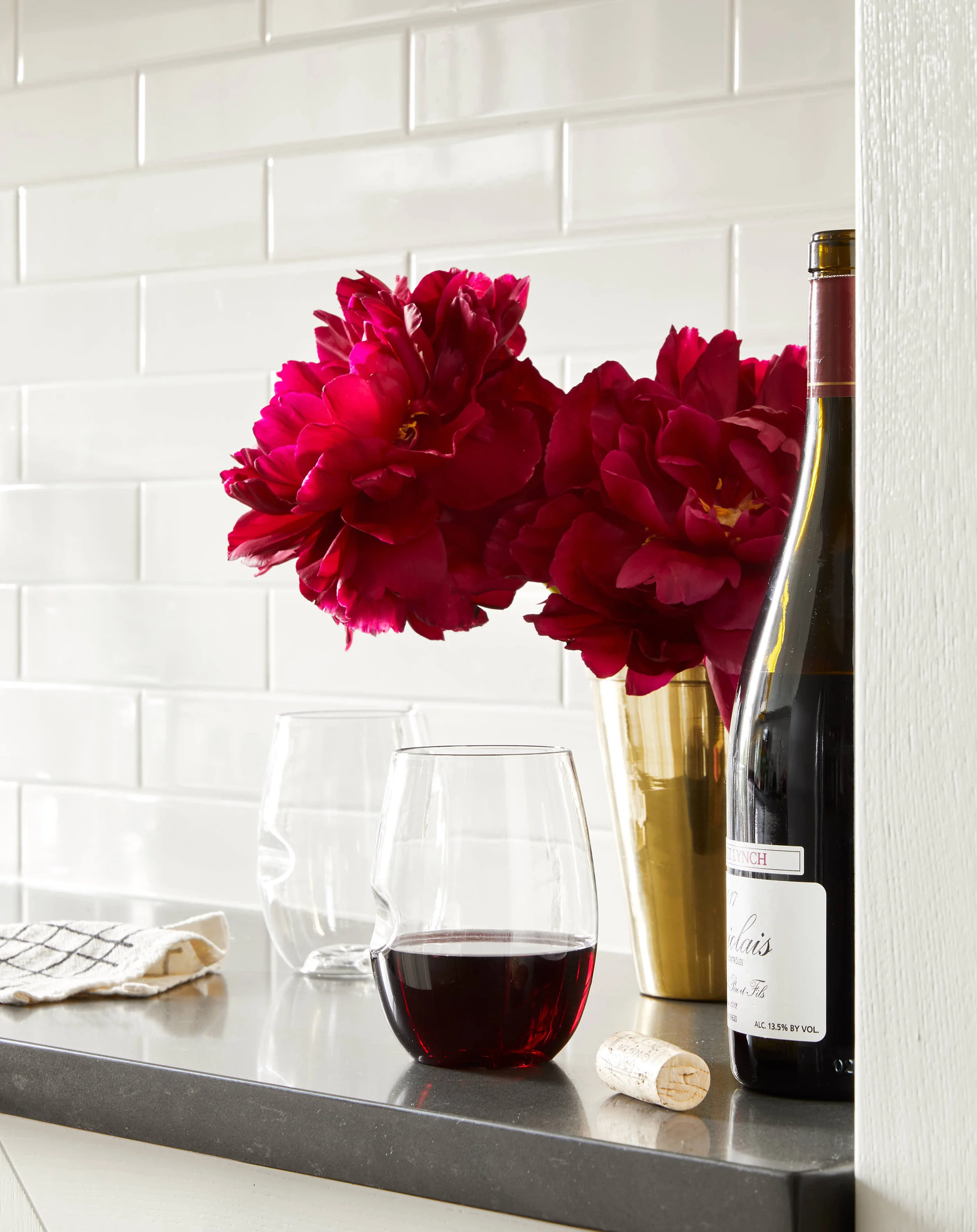 kate sears editorial nyc art director govino unbreakable red wine glass little korboose cotton napkin pink flowers bottle white subway tile happy hour dinner cork counter