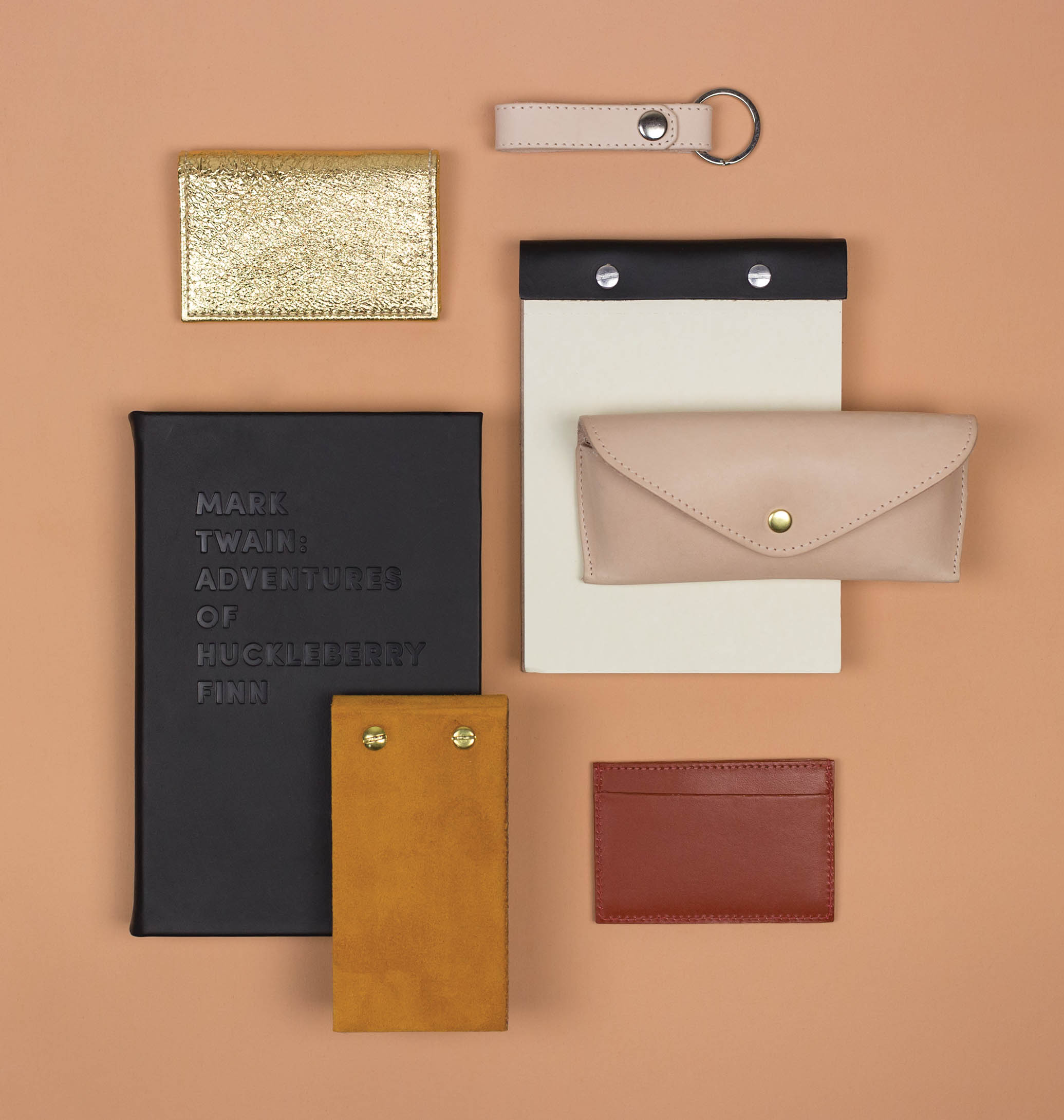 nyc designer art director graphic image x A/M Aesthetic Movement New York leather stationery recovered book huck finn twain eyeglass case note pad key chain wallet gold black cream oxblood