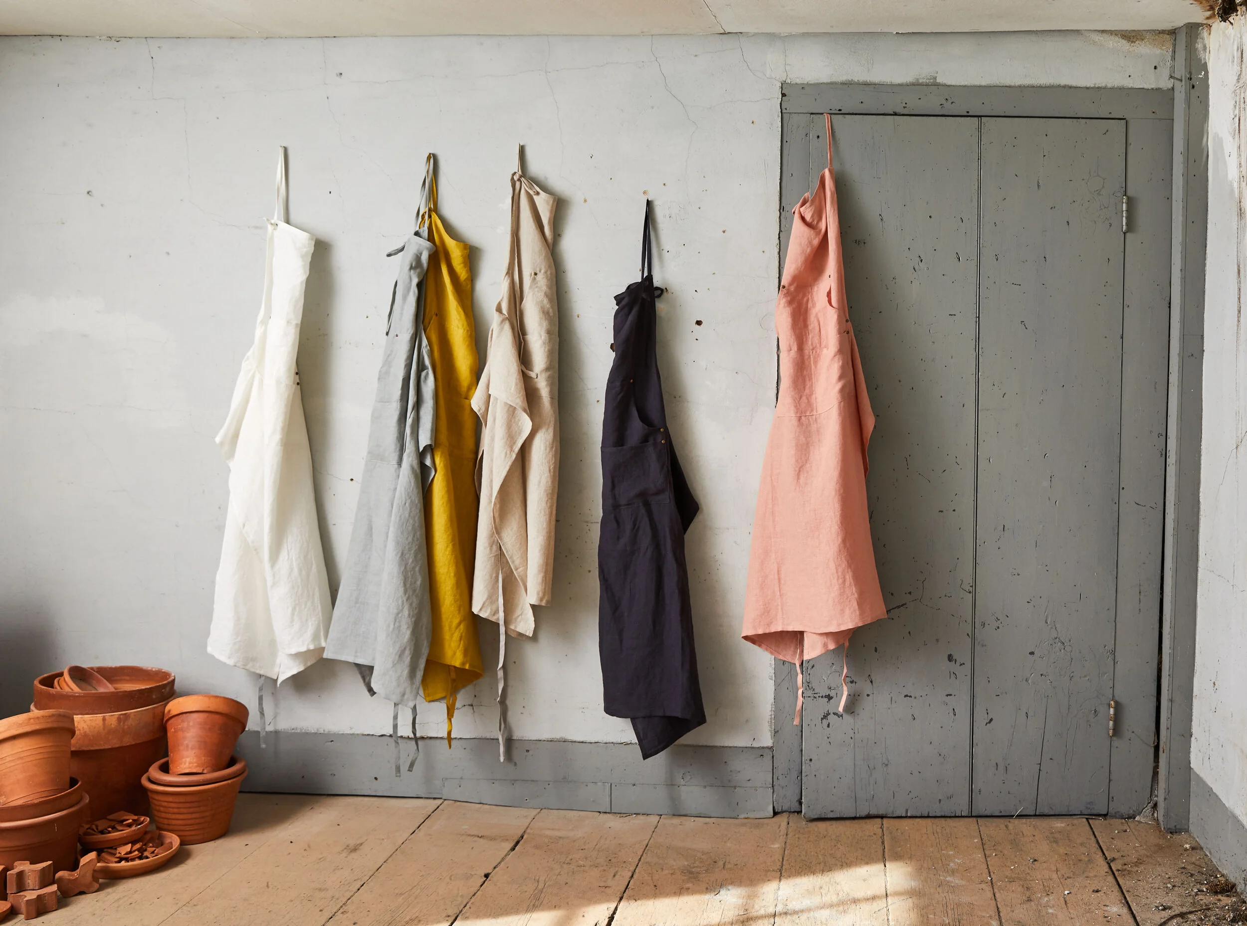 gift home aesthetic movement wholesale art director nyc sir/madam sirmadam cotton linen aprons barn gardening shed hanging door salmon pink wood floor workshop