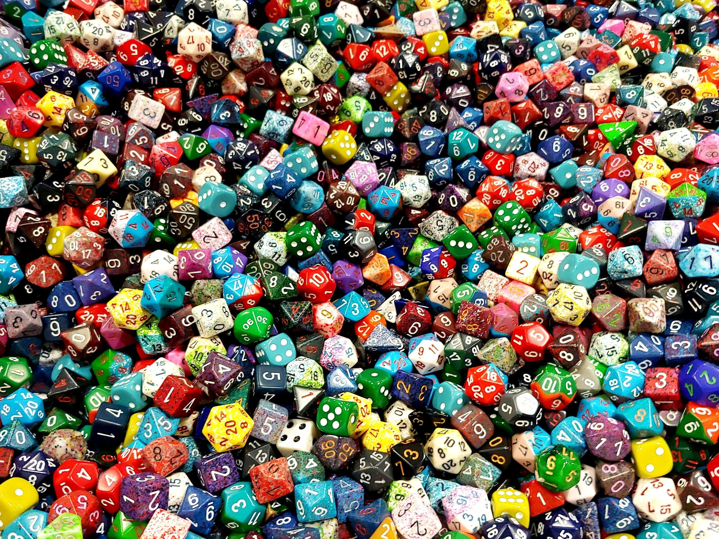 A large collection of multi-colored gaming dice including twenty-sided, twelve-sided, ten-sided, eight-sided, six-sided, and four-sided dice.