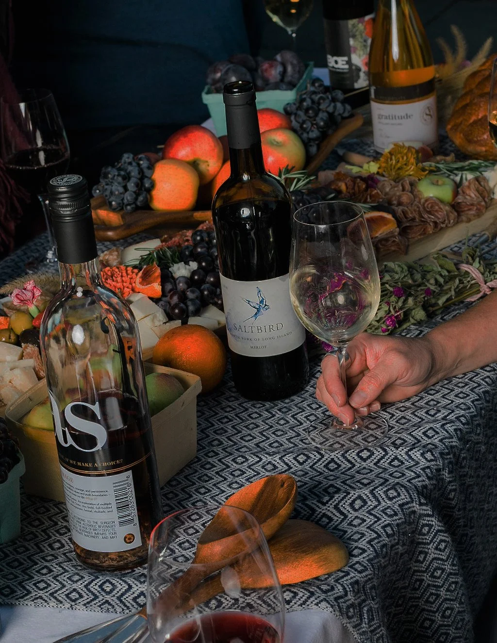 A table scape featuring Saltbird Cellars and As If Wines with an abundance of fruits and light bites.