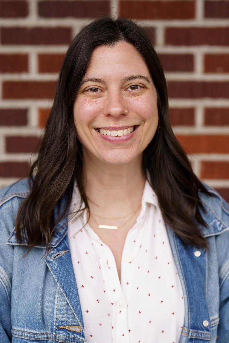 Photo of our teacher Alex who has mid length brown hair and a smile.