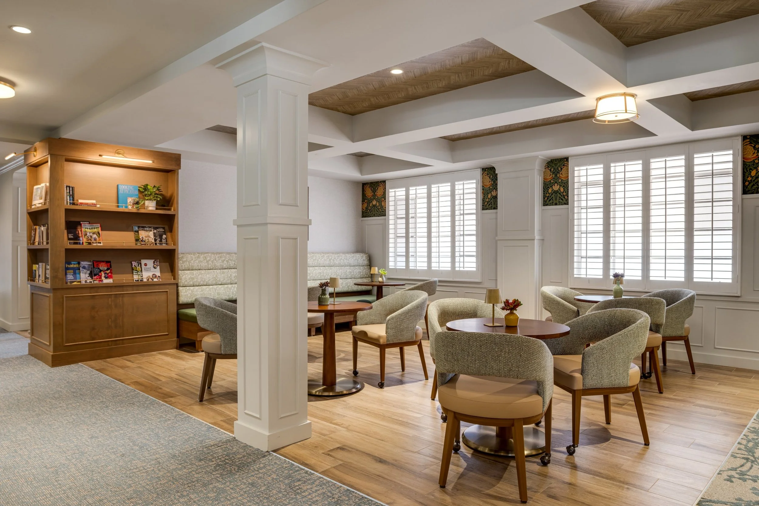 Seating nook with a bookshelf and round tables at Claremont Manor, photographed by a Los Angeles interior photographer