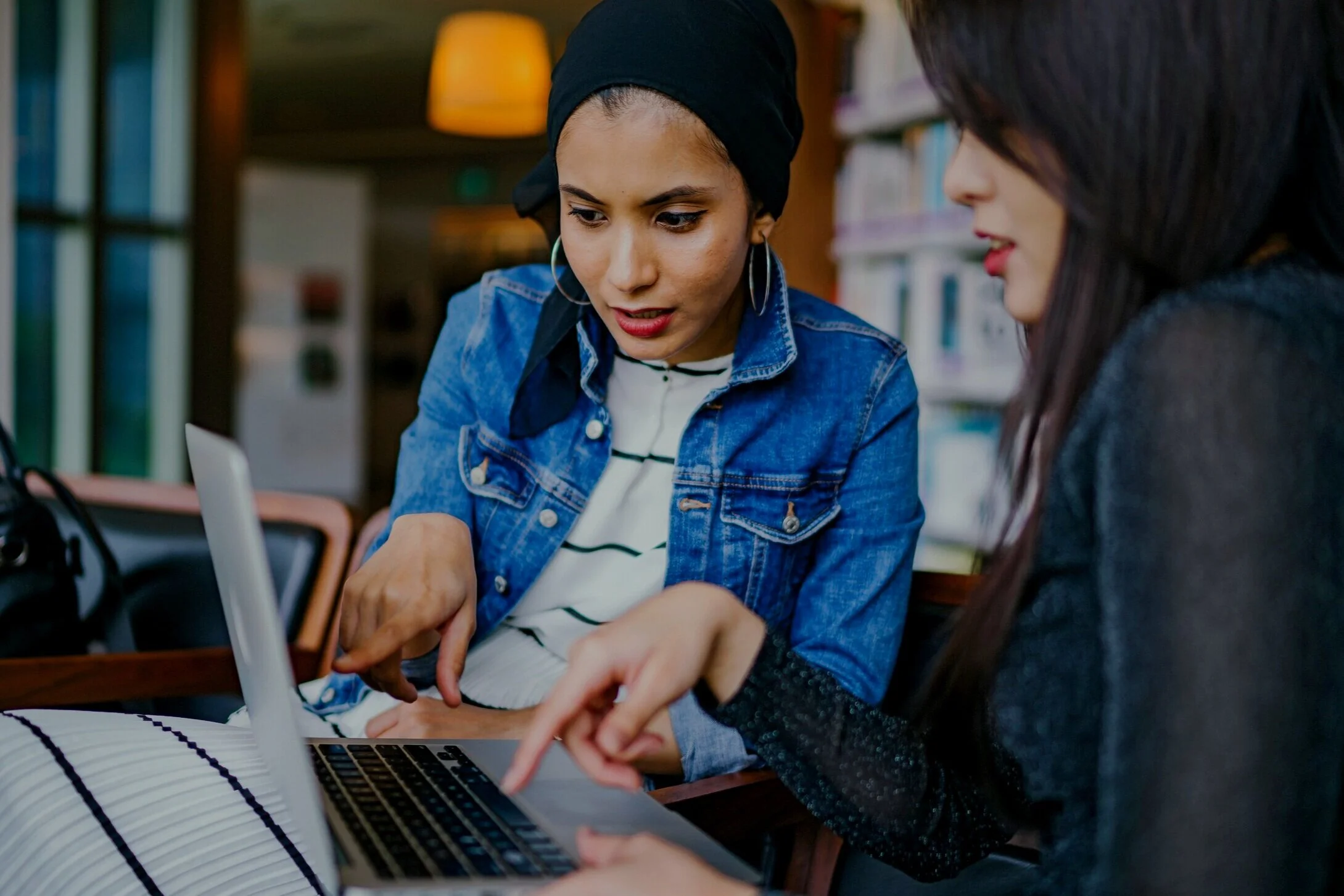 two-women-looking-and-pointing-at-macbook-laptop-1569076.jpg