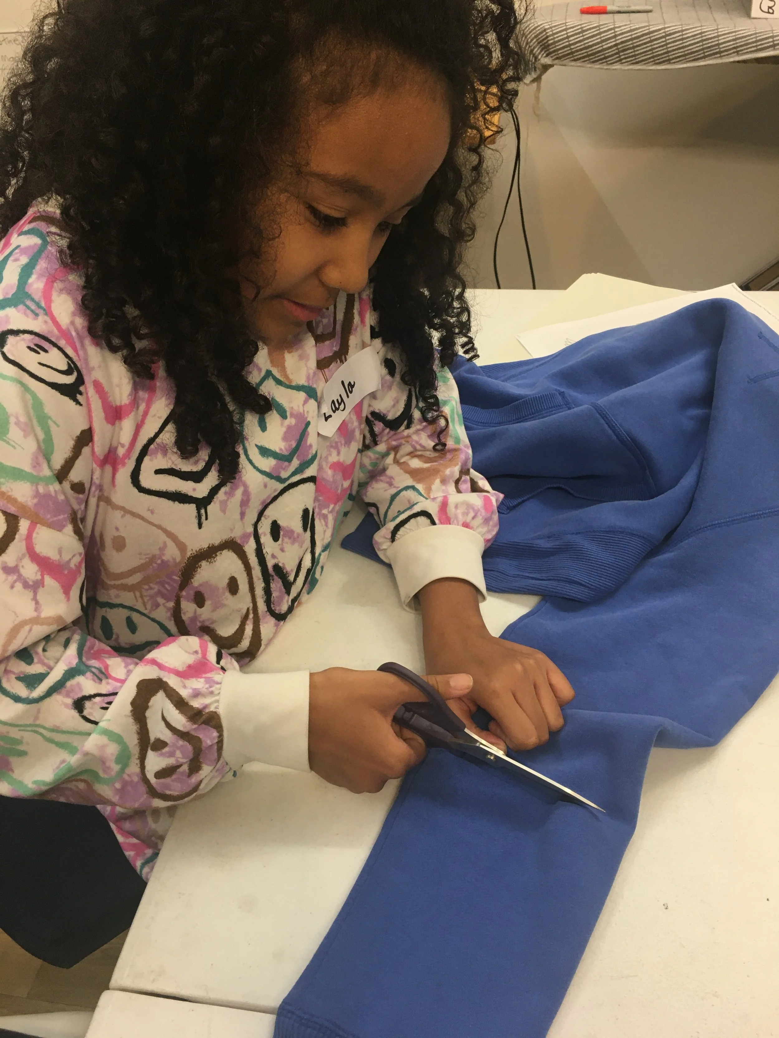 designer cutting out and customising clothes