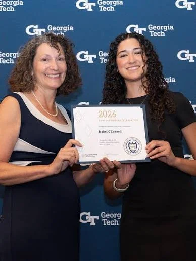 A woman receiving GT Woman's Club scholarship in front of a Georgia Tech backdrop, celebrating an achievement in 2026.