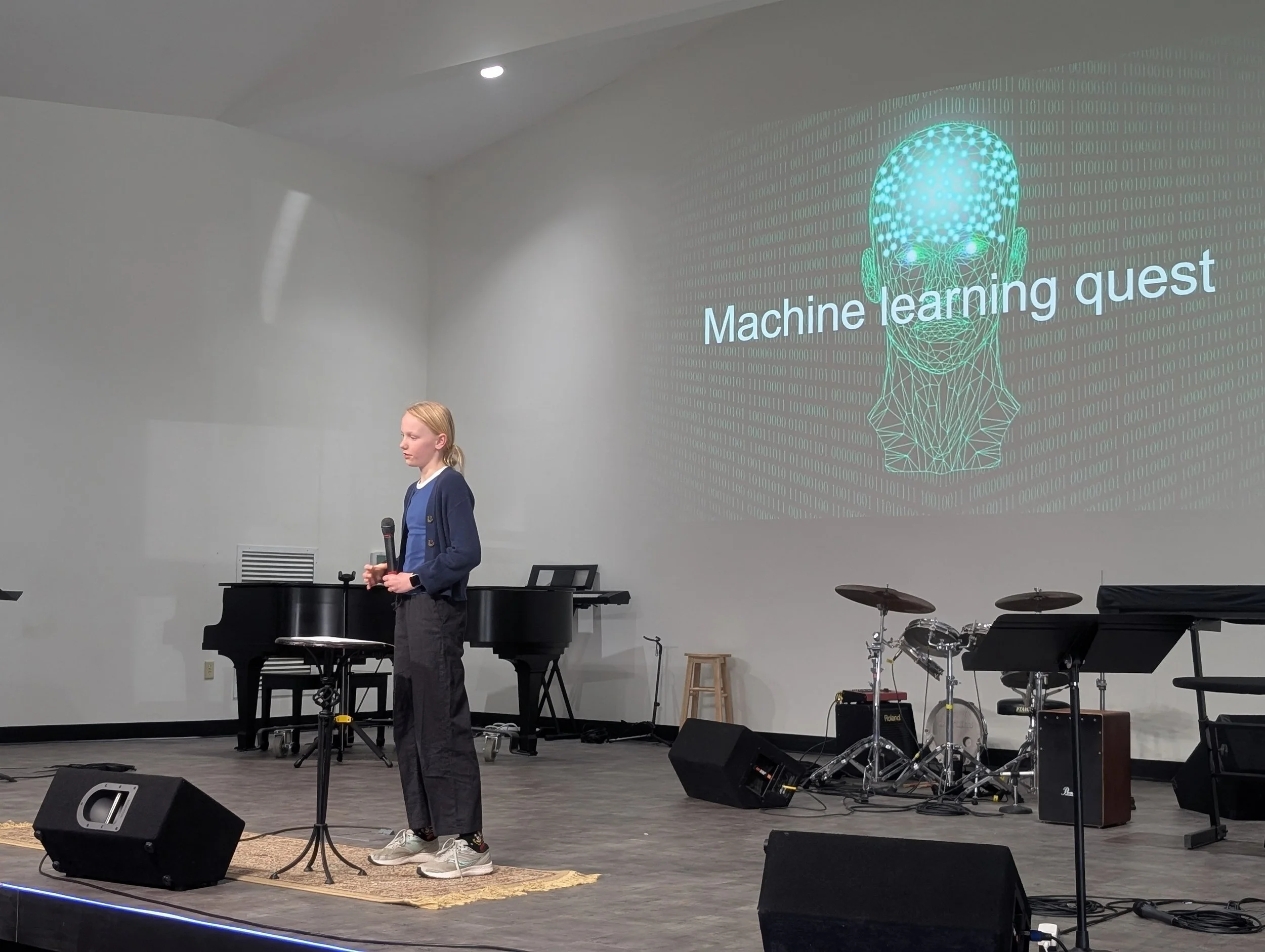 Learner presenting on stage during machine learning quest