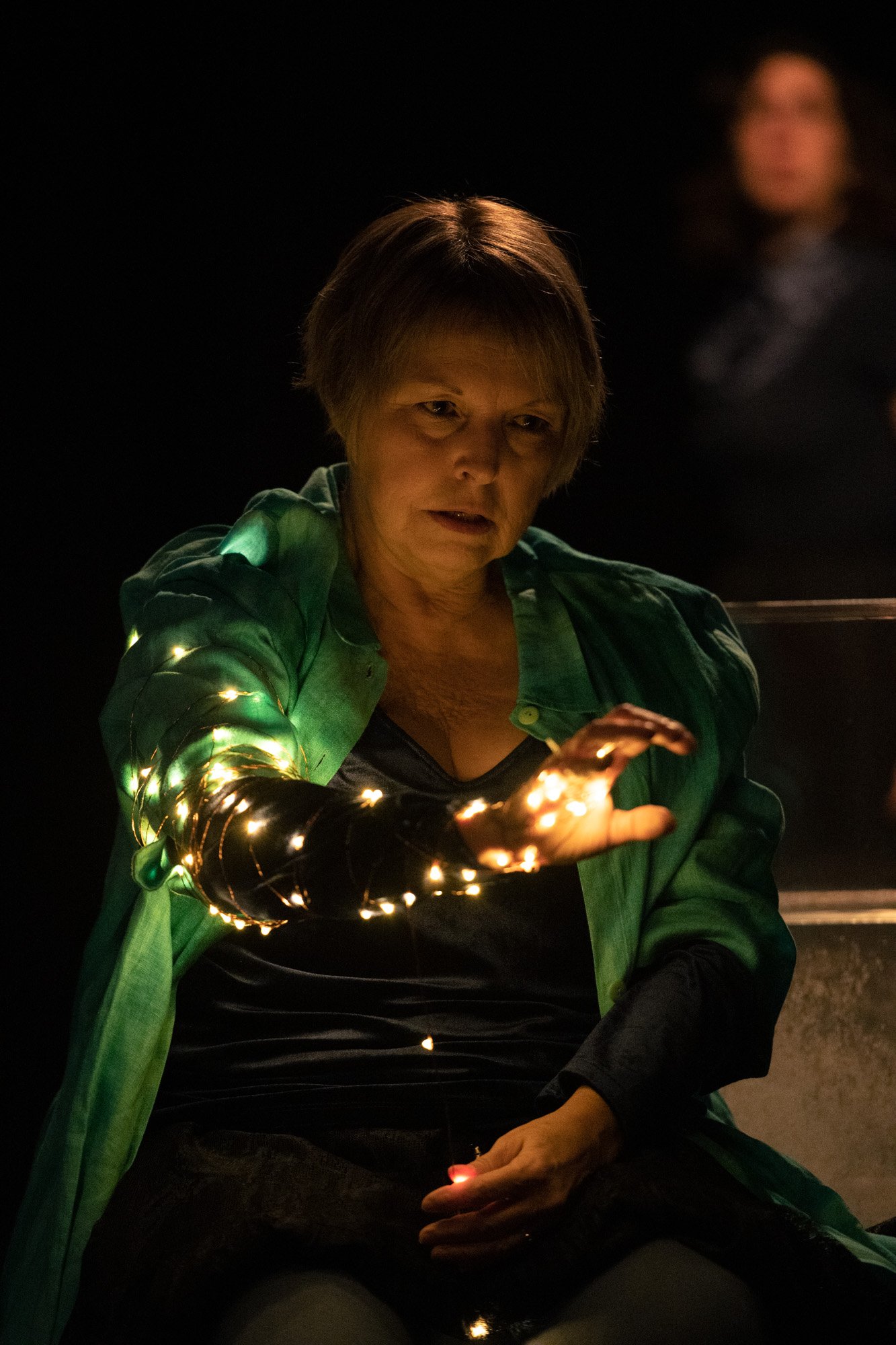 Une Marie (Christiane) le bras entouré d'une guirlande lumineuse.