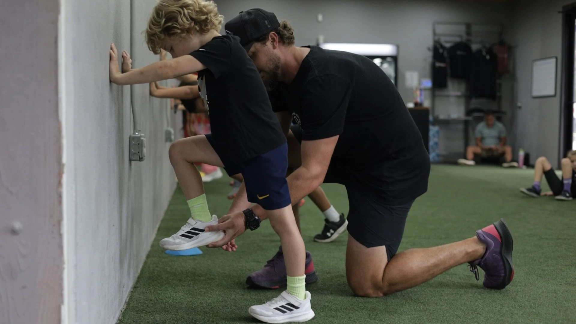 Perform24 coach providing one-on-one movement coaching to a young athlete during Project Speed group training in Tampa.