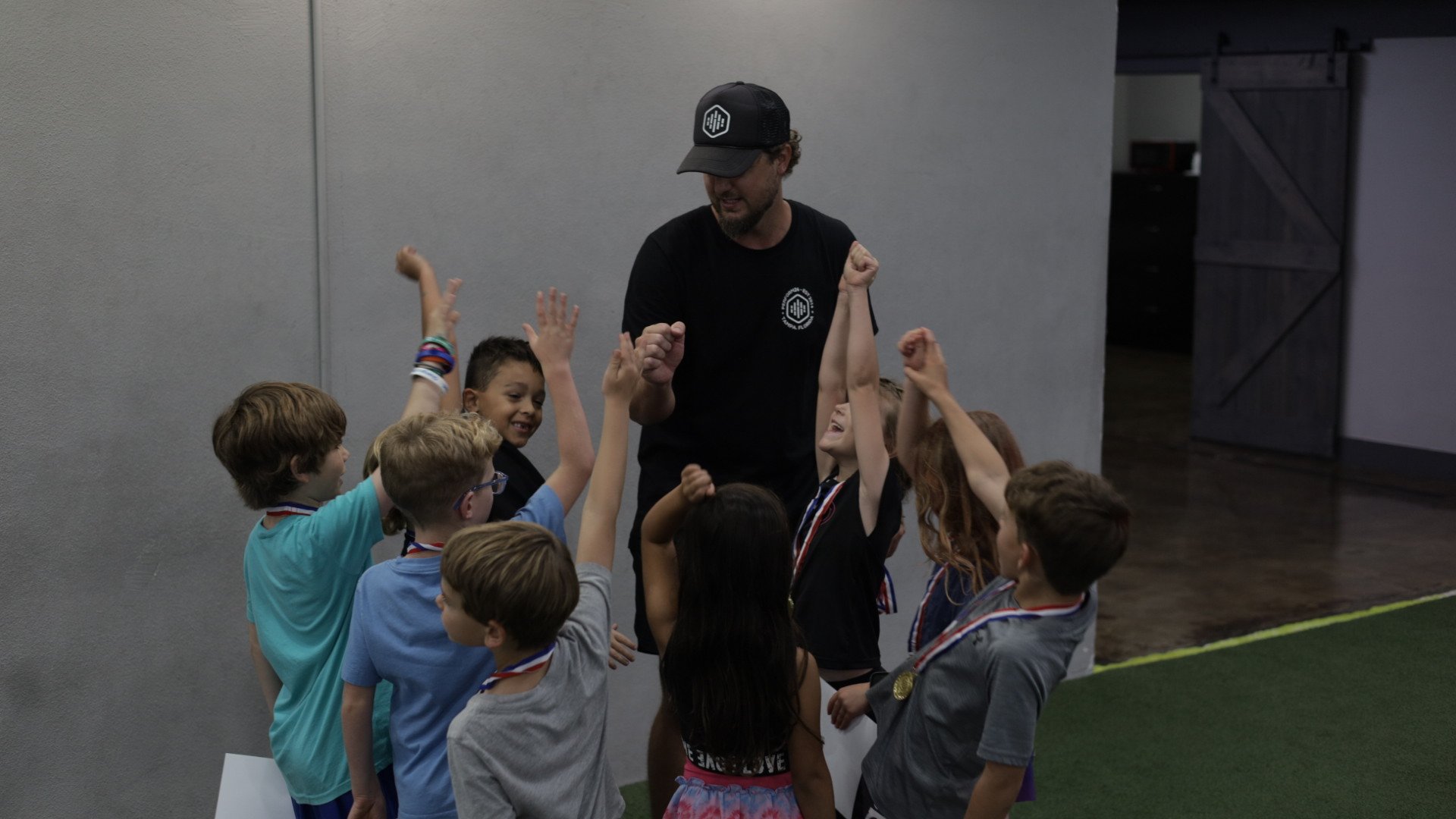 Youth athletes celebrating after a Project Speed training session with their coach at Perform24 in Tampa, Florida.