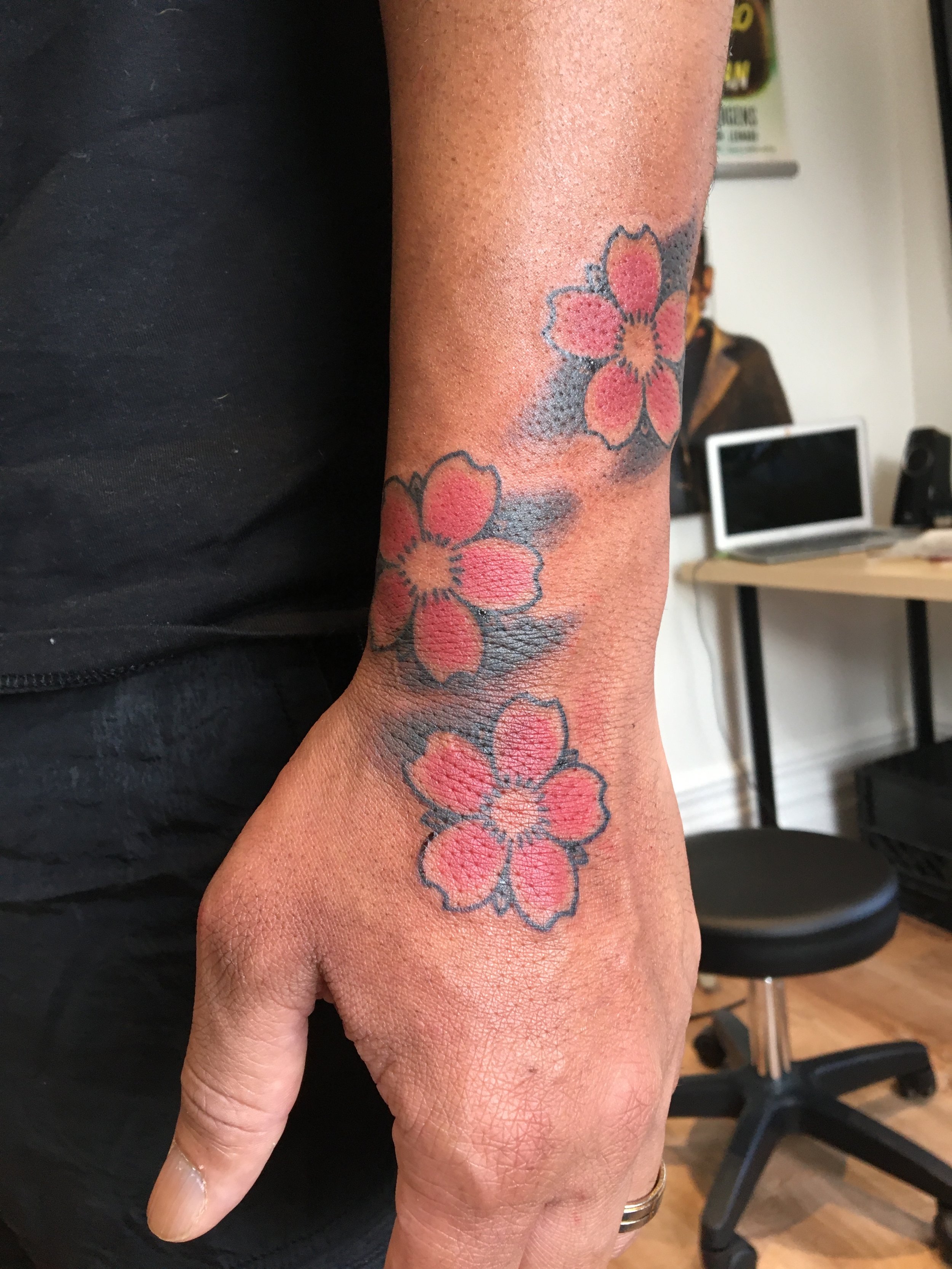 Full colour cherry blossom hand tattoo by Tyson Ward
