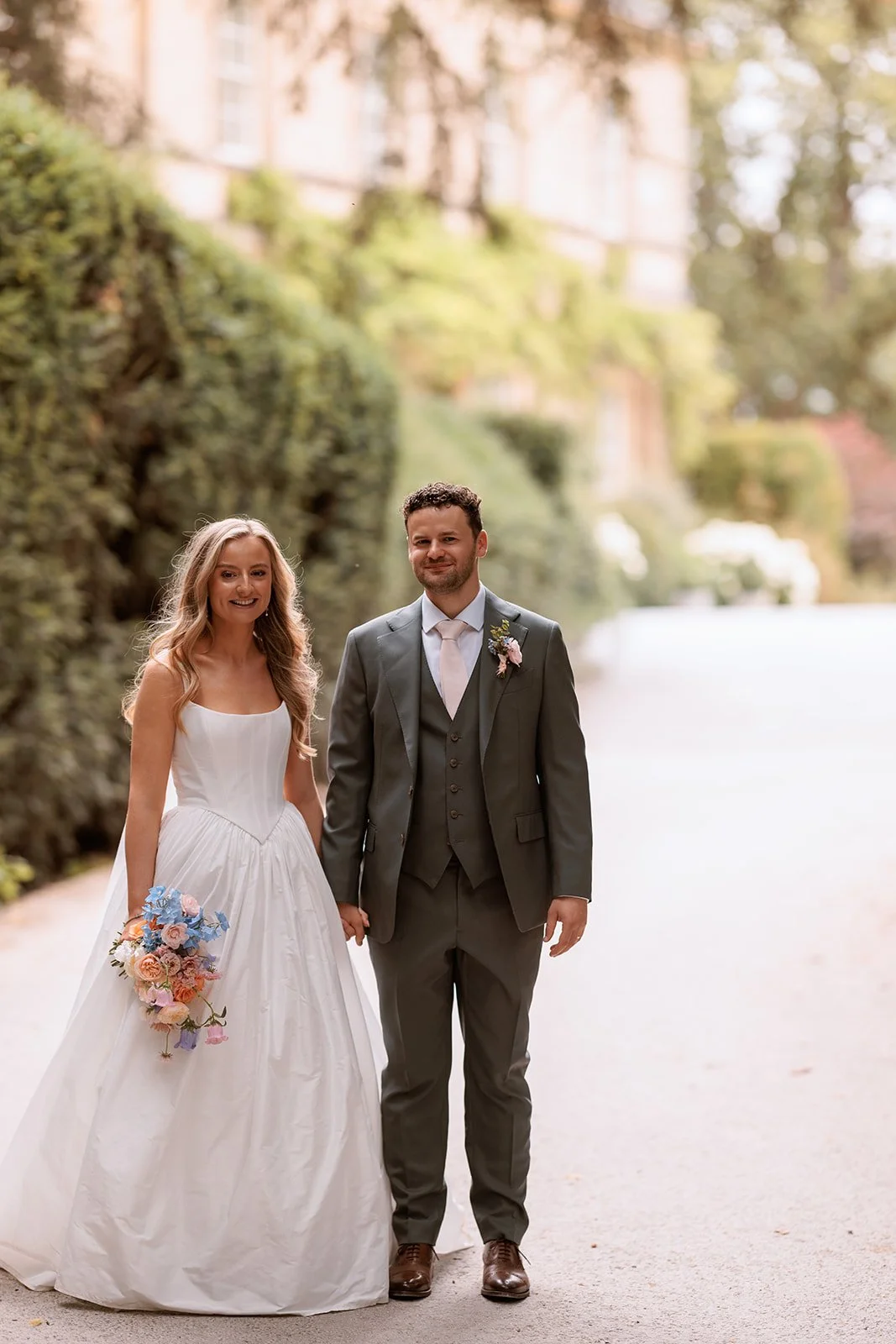 bride and groom at Middleton Lodge bride holding beautiful summer bouquet in pastel shades of pinks, corals, lilac and delphinium blue
