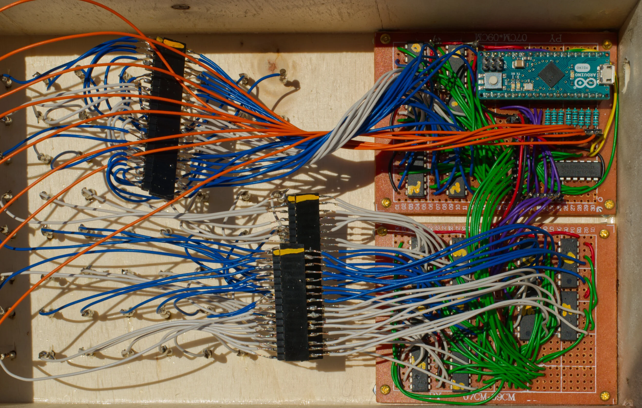  Control Logic inisde the wooden base of the HoloVox.  On the left are the connectors to the LED cube. On the right are the two boards controlling the display.  The top board holds the Arduino Micro, an 8-bit shift register for going through the laye