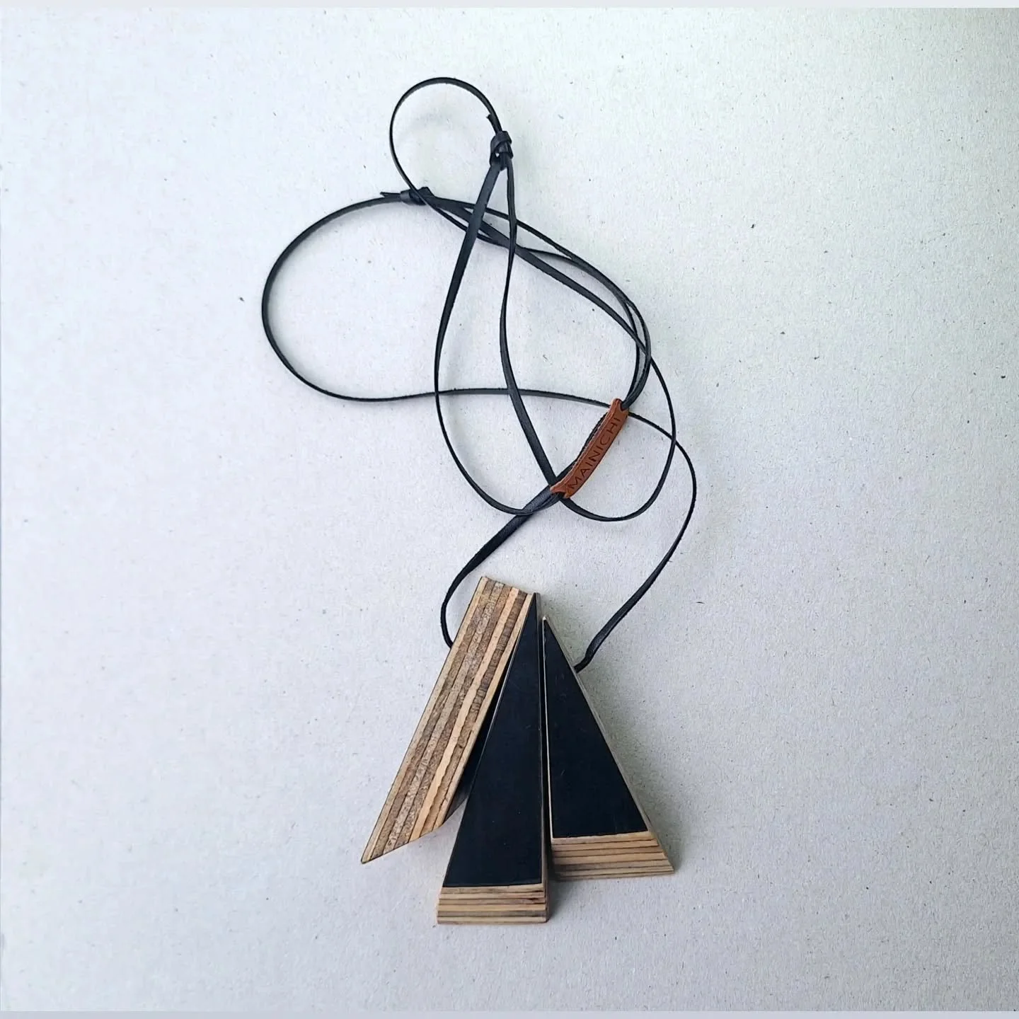 Recycled form ply offcuts create a dynamic, sculptural necklace.  Form ply is a waste product from the construction industry - used for concrete forming - and has a black finish on each face with layers of plywood visible between.
Get your own sculp