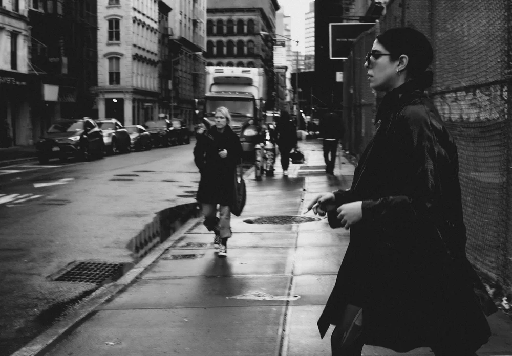 Unbothered: a woman in sunglasses walking through SoHo, New York, in black and white