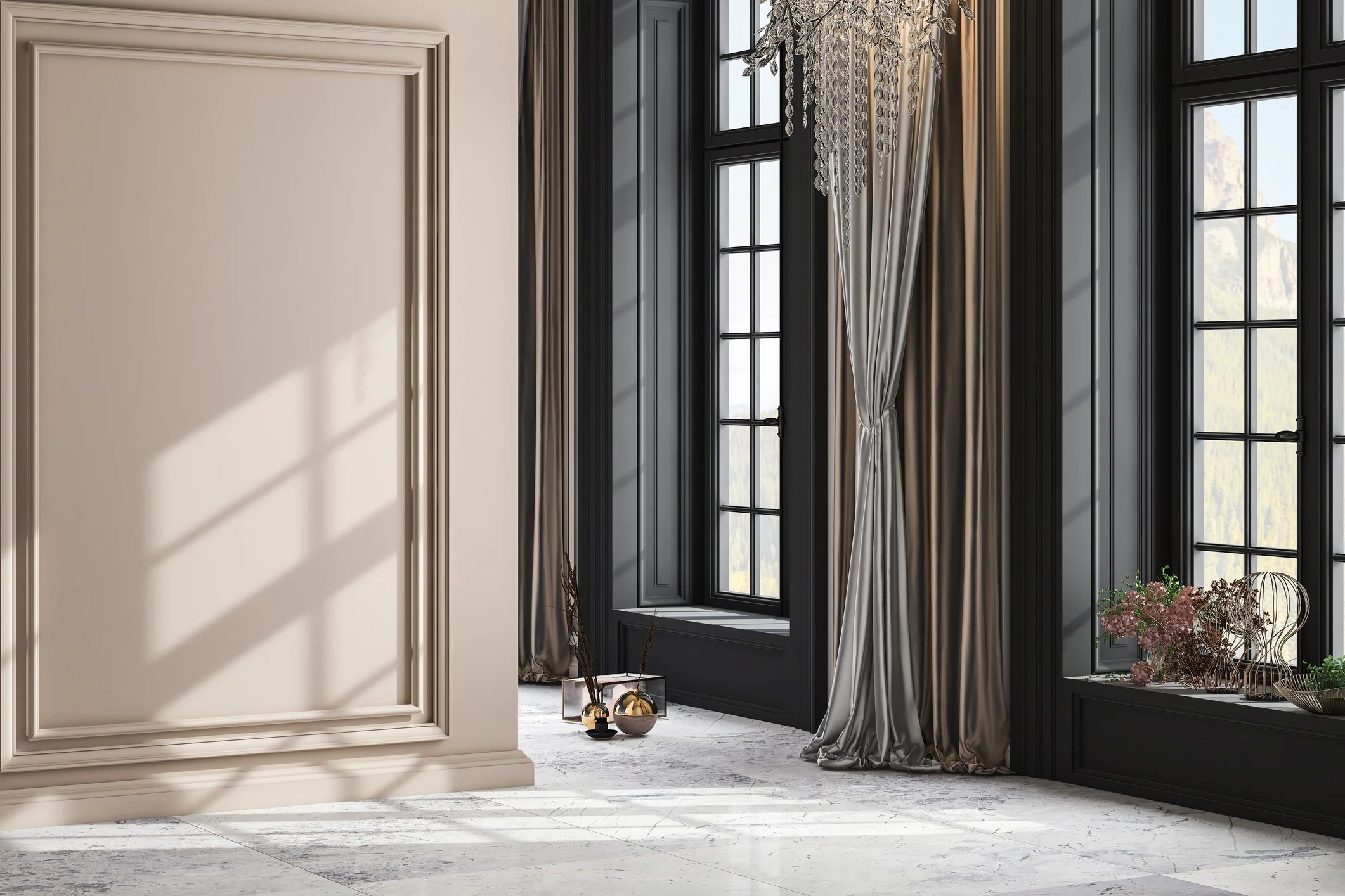 Interior view of a room with large black-framed windows, a beige decorative wall molding, and a chandelier with hanging crystals. There are beige and gray curtains, with a vase of pink flowers and metallic decorative objects on the floor.