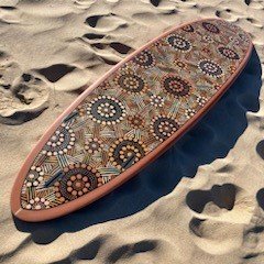 Indigenous art on a surfboard on the beach