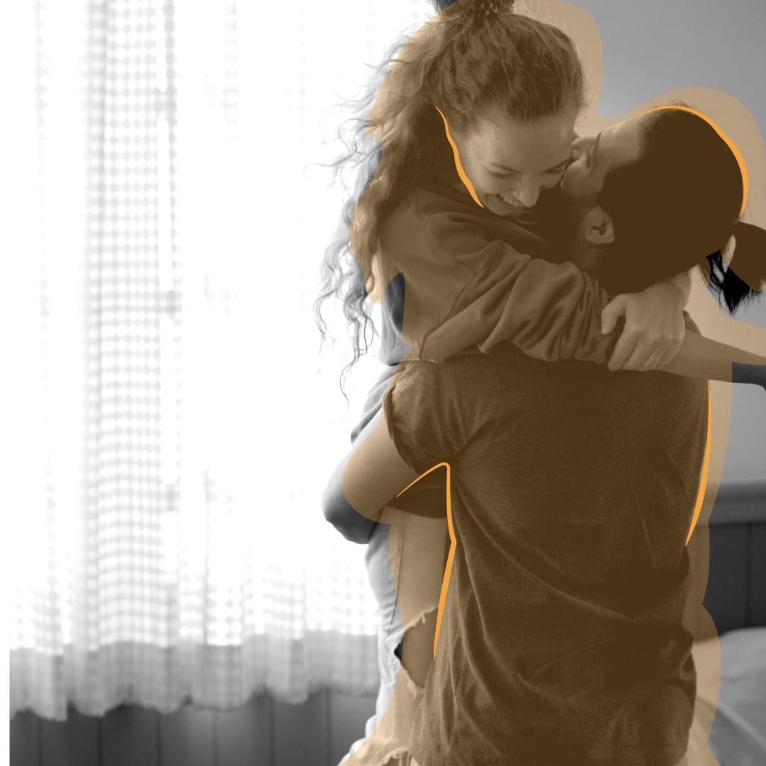 Heterosexual couple hugging in bedroom