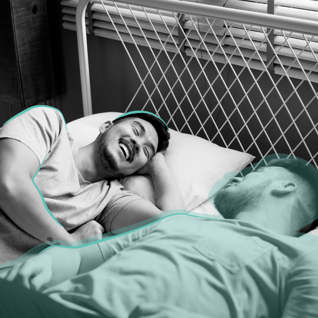 Same sex couple laughing while lying in bed
