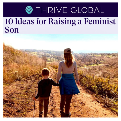 A woman and a young boy walking on a dirt trail in a hilly, rural landscape during the day. The woman is holding the boy's hand and they are facing away from the camera.