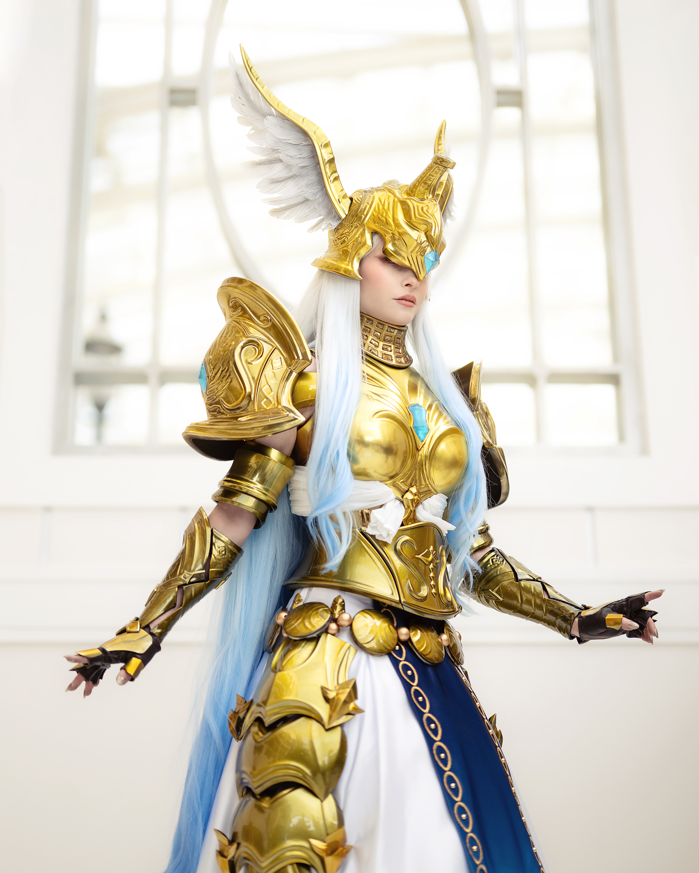 Bindi Smalls in a finished gold and white armored costume with a winged helmet, showcasing polished custom fabrication.