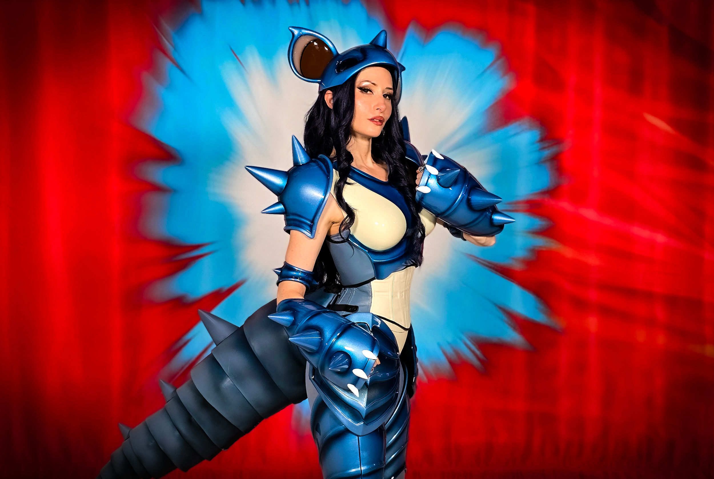 Bindi Smalls in a handmade Nidoqueen-inspired costume with blue armor against a red and blue backdrop.