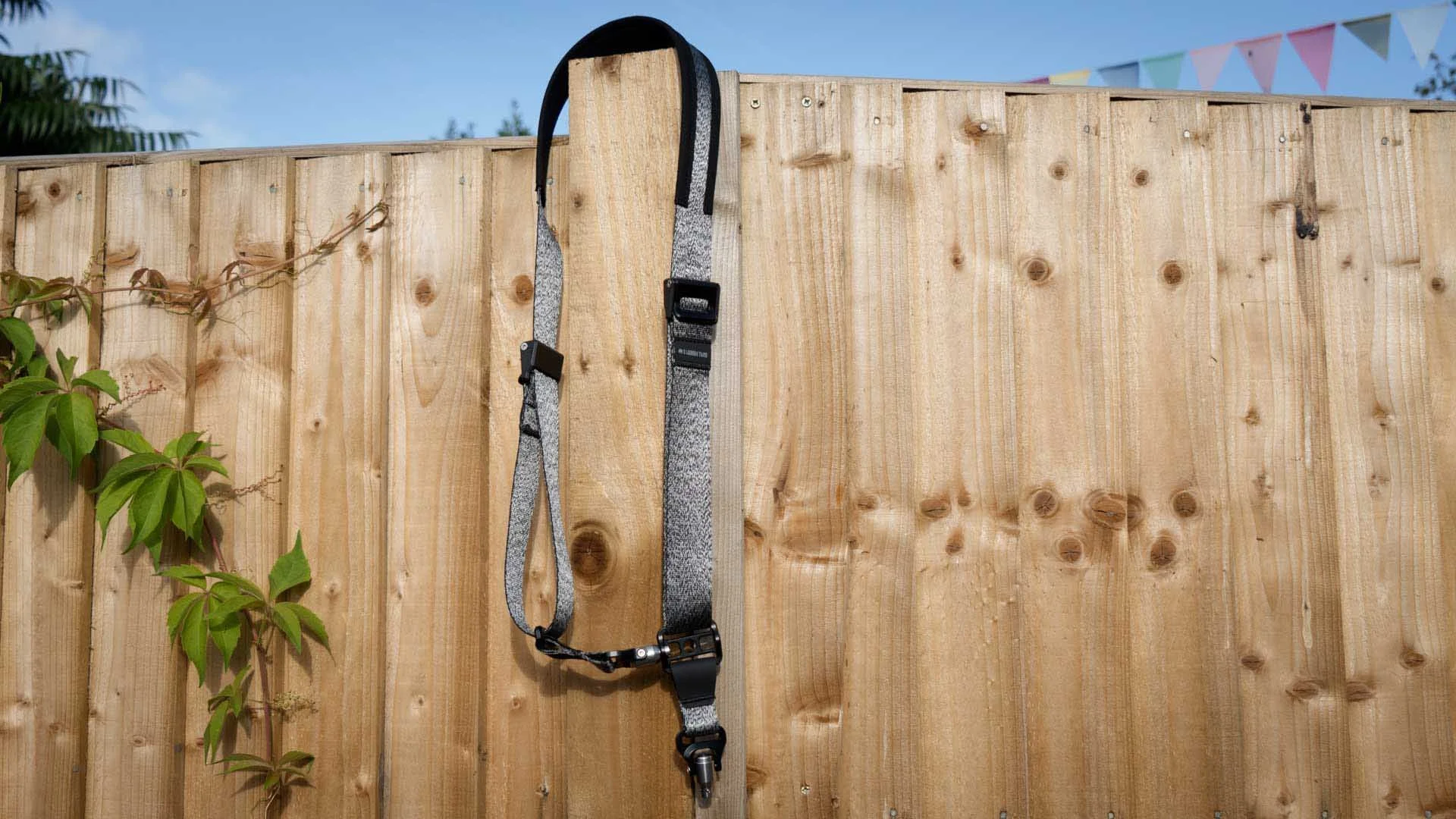 the 3 Legged Thing Axis 34P strap hanging from a fence post
