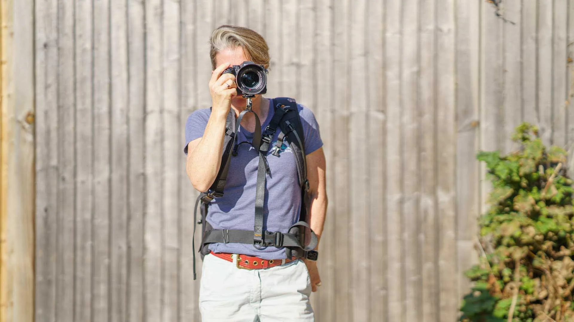Angela Nicholson holding a camera attached to a 3 Legged Thing Axis Anywhere strap