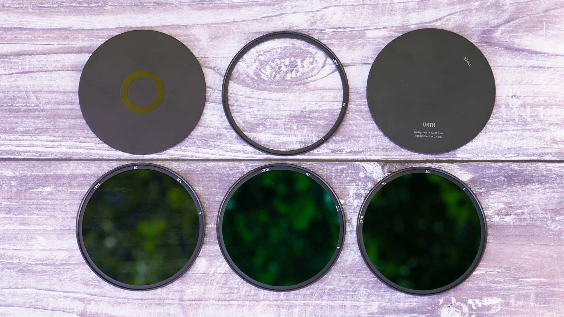 The Urth Magnetic ND Selects Filter Kit Plus+, showing from left to right, top: end cap 1, magnetic adapter ring, end cap 2, bottom: ND 8, ND 64, ND 1000.