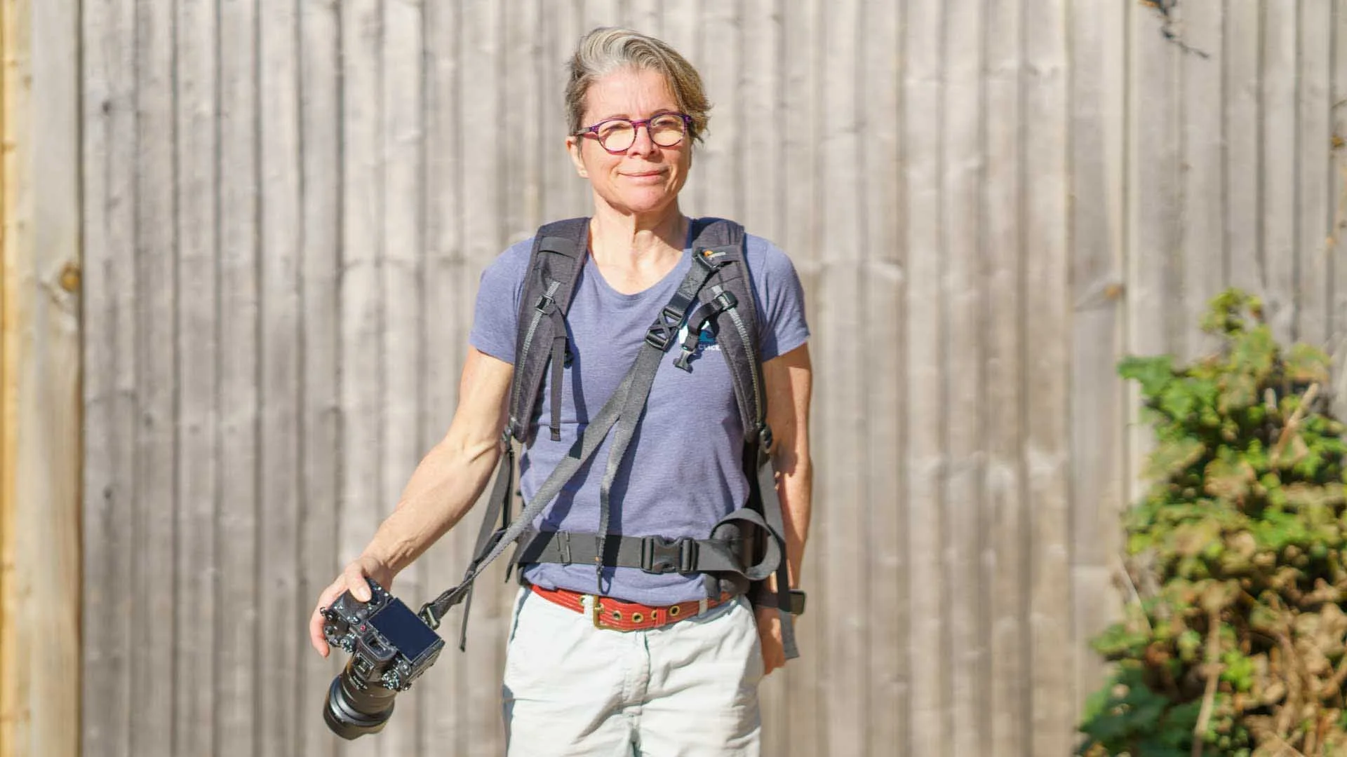 Angela Nicholson holding a camera attached to a 3 Legged Thing Axis Anywhere strap