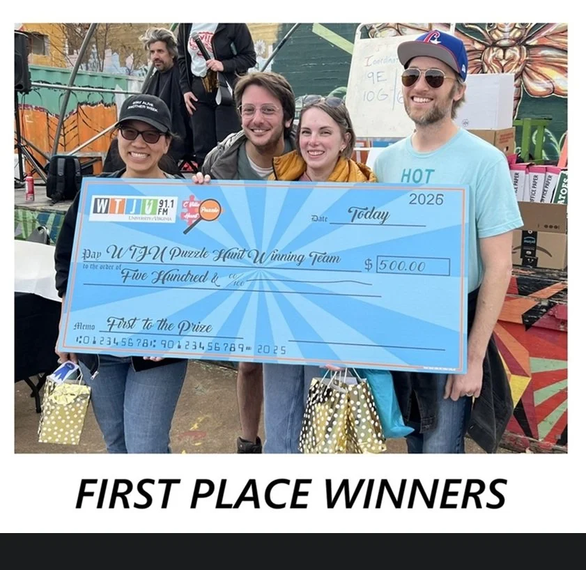 A group of four people, the first place winners, stand with a large blue $500 cheque with the WTJU and C'Ville Puzzle Hunt logos on it.