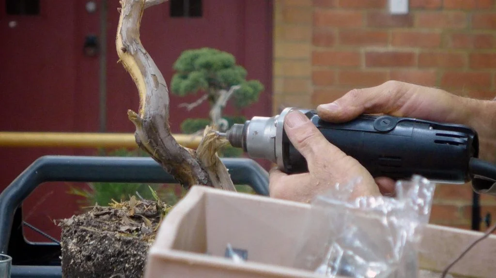 Using a power tool to shape a jin.