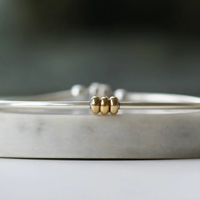 Silver bracelet with 3 gold chunky rings