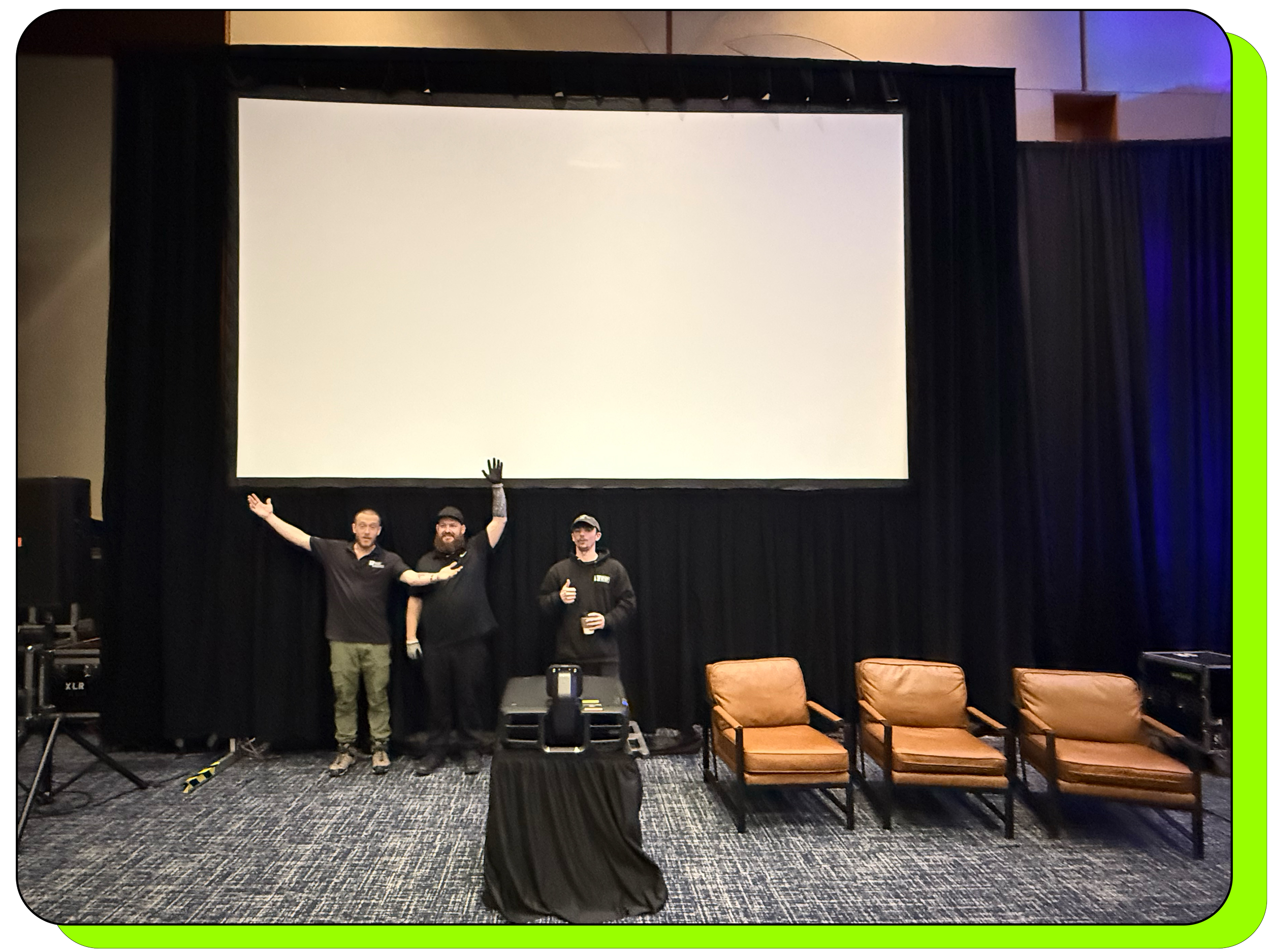 Team of AV techs from T/22 standing in front of a large projection screen