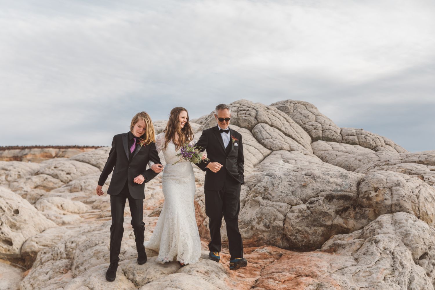 bride-walks-over-sandstone-with-friends
