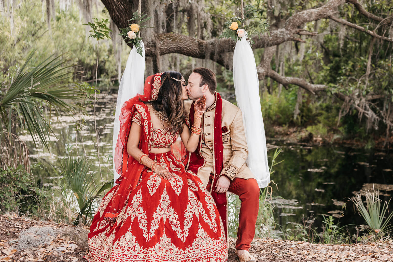  Bride and groom kiss on tree swing under weeping willow 