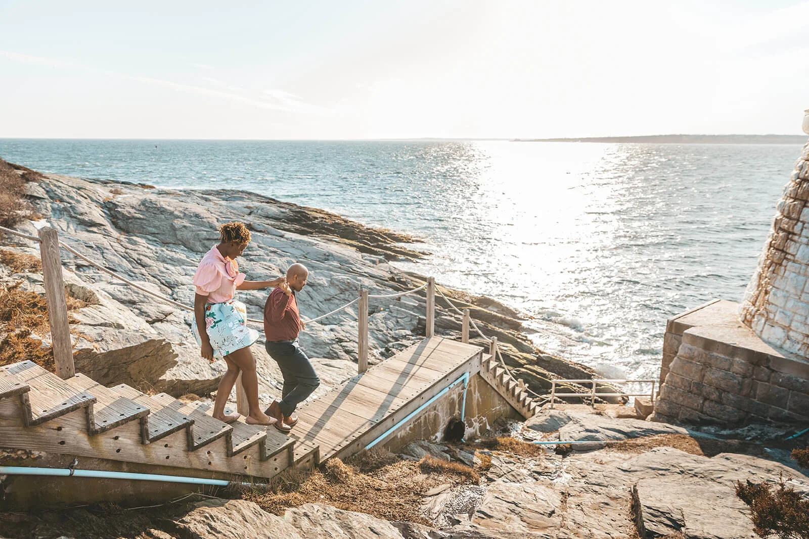  Couple goes down the stairs to the lighthouse in Newport, RI 