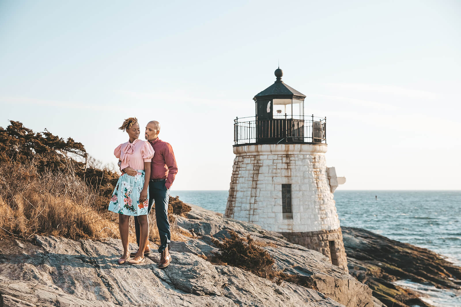  Couple embrace in front of Castle Hill Lighthouse in Newport, RI in celebration of their 10 year anniversary. The area has an amazing ocean view 