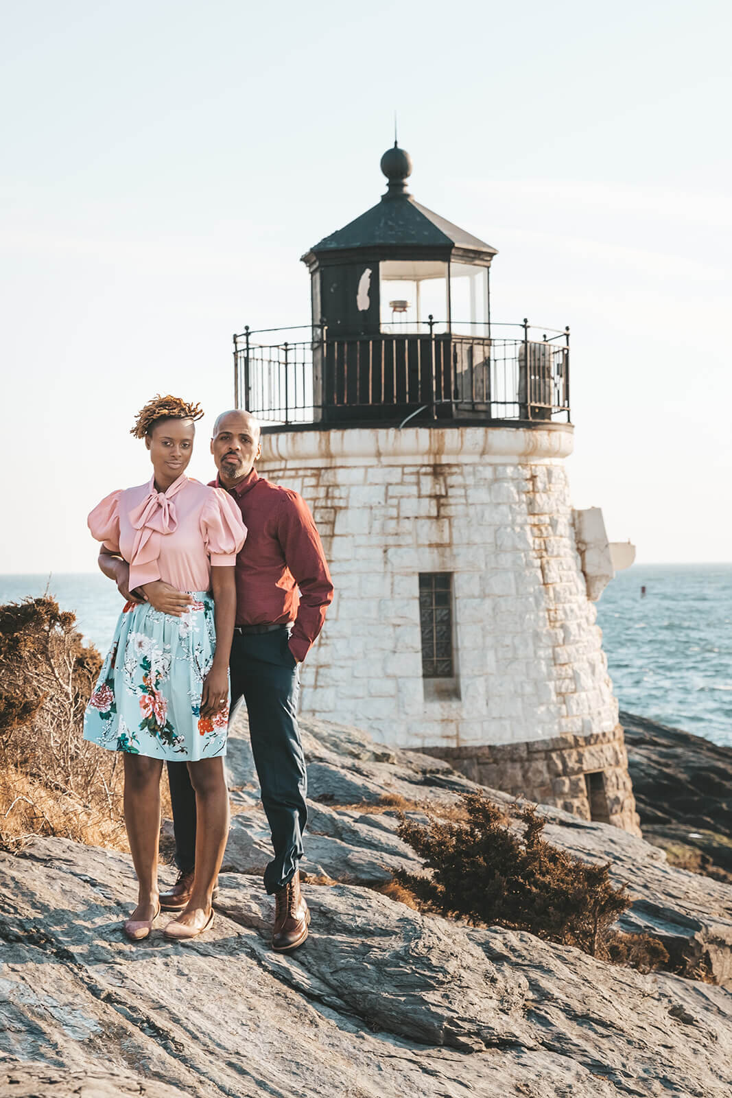  Couple embrace in front of Castle Hill Lighthouse in Newport, RI in celebration of their 10 year anniversary 