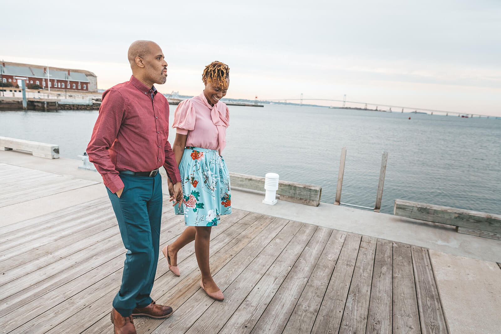  Couple walks down pier at Fort Adams State Park in Newport, Rhode Island 